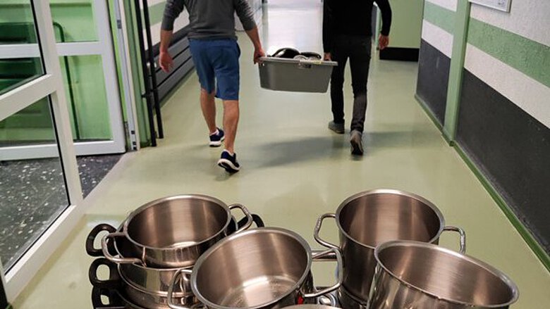 Schüler tragen Töpfe